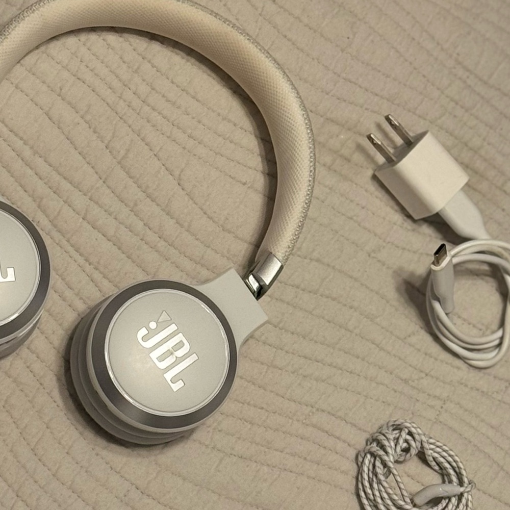 White JBL headphones with charger and headphone adapter